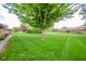 Expansive backyard with lush green grass and mature trees, perfect for outdoor activities and relaxation at 143 Asbury Dr # 86A, Anderson, IN 46013