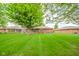 Well-manicured backyard featuring a sprawling lawn and a classic brick home, ideal for enjoying the outdoors at 143 Asbury Dr # 86A, Anderson, IN 46013