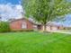 Well-maintained brick home with lush green lawn and mature landscaping at 143 Asbury Dr # 86A, Anderson, IN 46013