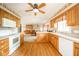 Spacious kitchen with oak cabinets, white appliances, and hardwood floors open to dining room at 143 Asbury Dr # 86A, Anderson, IN 46013