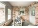 Sunroom featuring brick accent walls, multiple windows, and neutral carpeting at 143 Asbury Dr # 86A, Anderson, IN 46013