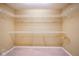 Empty walk-in closet featuring multiple wire shelving units and neutral carpeting at 143 Asbury Dr # 86A, Anderson, IN 46013