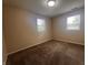 A neutral-toned bedroom with brown carpet, two windows offering natural light, and ample space at 1605 S Whittier Pl, Indianapolis, IN 46203