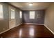 Bright living room features wood flooring, neutral paint, two windows with blinds, and a back entry door at 1605 S Whittier Pl, Indianapolis, IN 46203