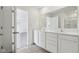 Bathroom featuring a double sink vanity, quartz countertop, large mirror, and view into bedroom at 1614 N Clearwater Dr, Greenfield, IN 46140