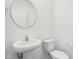 Powder room featuring modern fixtures, pedestal sink, and a round mirror at 1614 N Clearwater Dr, Greenfield, IN 46140