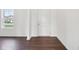 Bright, empty room showcasing new dark hardwood floors and a door and window with outside view at 1614 N Clearwater Dr, Greenfield, IN 46140