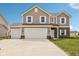 Charming two-story home features white-trimmed windows, a three-car garage, and a concrete driveway at 1614 N Clearwater Dr, Greenfield, IN 46140
