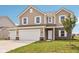 Beautiful two-story home boasts a three-car garage, brick accents, and a well-maintained lawn at 1614 N Clearwater Dr, Greenfield, IN 46140