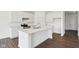 Modern kitchen with white cabinets, stainless steel appliances, and a large island with quartz countertops at 1614 N Clearwater Dr, Greenfield, IN 46140