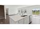 Modern kitchen island with stainless steel appliances and backyard views from the sliding glass door at 1614 N Clearwater Dr, Greenfield, IN 46140
