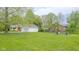 Spacious backyard with mature trees, detached garage and a seating area with a fire pit at 1709 E Loretta Dr, Indianapolis, IN 46227
