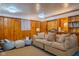 Finished basement featuring knotty pine walls, cozy seating, and built-in bookshelves at 1709 E Loretta Dr, Indianapolis, IN 46227