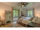 Bright bedroom featuring a large mirror, ceiling fan, neutral color scheme, and large windows at 1709 E Loretta Dr, Indianapolis, IN 46227