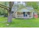 Charming single-story home with stone accents, covered porch and a swing hanging from a mature tree at 1709 E Loretta Dr, Indianapolis, IN 46227