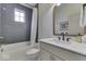Well-lit bathroom with a tub, a dark tiled wall, and a stylish vanity and mirror at 17346 Newton Main St, Westfield, IN 46074