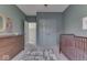 Light green bedroom with crib, dresser, and double doors leading to an ensuite at 17346 Newton Main St, Westfield, IN 46074