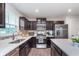 Modern kitchen with stainless steel appliances, granite countertops, and dark wood cabinets at 17949 Scout Ln, Westfield, IN 46074