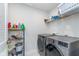 Efficient laundry room equipped with modern washer, dryer, and storage shelves at 17949 Scout Ln, Westfield, IN 46074