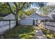Detached garage in a fenced backyard, accessible by a brick pathway and surrounded by greenery at 2016 Central Ave, Indianapolis, IN 46202