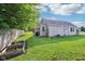 The grassy backyard with raised garden beds has plenty of sunshine for gardening and outdoor activities at 2025 E Broadway St, Fortville, IN 46040