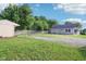 A backyard showcases a lush, green lawn, a gravel area, and an outbuilding for ample outdoor enjoyment at 2025 E Broadway St, Fortville, IN 46040