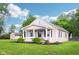 This quaint home boasts a charming front porch, attractive landscaping, and a spacious, manicured lawn at 2025 E Broadway St, Fortville, IN 46040