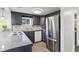 Well-lit kitchen with stainless steel refrigerator, grey cabinets, and stylish backsplash at 2025 E Broadway St, Fortville, IN 46040
