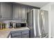 Kitchen featuring stainless steel refrigerator, microwave and grey cabinets with granite countertops at 2025 E Broadway St, Fortville, IN 46040