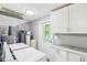 Functional laundry room with modern appliances, storage cabinets, and a utility sink at 2025 E Broadway St, Fortville, IN 46040