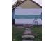 Shows the partially renovated exterior featuring horizontal siding, concrete block foundation, and an A-frame roof at 2134 Dr Andrew J Brown Ave, Indianapolis, IN 46202