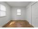 Bright bedroom with windows, hardwood floors, white walls, and double door closet at 2344 N Leland Ave, Indianapolis, IN 46218