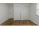 An empty bedroom featuring rustic hardwood floors, white walls and trim and two large closets at 2344 N Leland Ave, Indianapolis, IN 46218