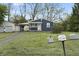 Exterior shot of the home and detached garage from the yard showcasing lush lawn and mature trees at 2344 N Leland Ave, Indianapolis, IN 46218