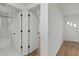 Bright hallway leading to a bathroom and rooms with hardwood floors, showcasing natural light at 2344 N Leland Ave, Indianapolis, IN 46218