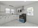 An updated kitchen features white cabinets and marble countertops, a black sink and stainless appliances at 2344 N Leland Ave, Indianapolis, IN 46218