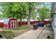 Landscaped backyard featuring a red shed, lush trees, and well-maintained lawn at 2726 Dawson St, Indianapolis, IN 46203