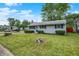 Well-manicured lawn and landscaping enhance this charming single-story home with blue shutters at 2726 Dawson St, Indianapolis, IN 46203