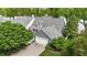 Aerial view of home with a two-car garage, shingled siding, green lawn, mature trees, and close proximity to the lake at 3602 Bay Rd S Dr, Indianapolis, IN 46240