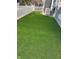 Backyard area features synthetic lawn, a white picket fence, and a central air conditioner at 3602 Bay Rd S Dr, Indianapolis, IN 46240