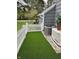 Backyard area features synthetic lawn, a white picket fence, and a home generator at 3602 Bay Rd S Dr, Indianapolis, IN 46240