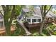 Exterior view of home with a wooden deck, stairs to the water, and surrounded by mature trees at 3602 Bay Rd S Dr, Indianapolis, IN 46240
