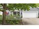 Inviting home exterior with a white garage door, picket fence, and lush greenery at 3602 Bay Rd S Dr, Indianapolis, IN 46240