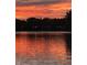 Picturesque sunset over a calm lake, reflecting vibrant colors, with trees in background at 3602 Bay Rd S Dr, Indianapolis, IN 46240