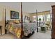 Serene main bedroom with a four-poster bed, decorative pillows, and natural light from a garden view at 3602 Bay Rd S Dr, Indianapolis, IN 46240