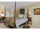 Spacious main bedroom featuring a four-poster bed, a writing desk, and warm-toned walls at 3602 Bay Rd S Dr, Indianapolis, IN 46240