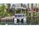 A view of a pontoon boat docked on a lake with a beautiful house and deck visible in the background at 3602 Bay Rd S Dr, Indianapolis, IN 46240