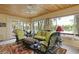 Bright sunroom with wood ceilings, walls of windows, comfortable seating, and views of a lake at 3602 Bay Rd S Dr, Indianapolis, IN 46240