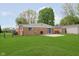 Well-maintained backyard with a brick house, patio, and expansive lawn area at 3723 S Dearborn St, Indianapolis, IN 46237