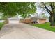 A single-story brick ranch home with a long driveway and detached garage at 3723 S Dearborn St, Indianapolis, IN 46237